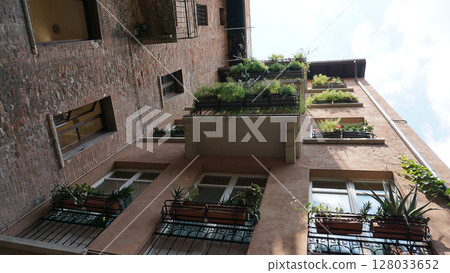 Beautiful traditional Italian building with flowers on balcony of medieval wall, Verona, Italy Beautiful traditional Italian building with flowers on balcony of medieval wall, Verona, Italy 128033652
