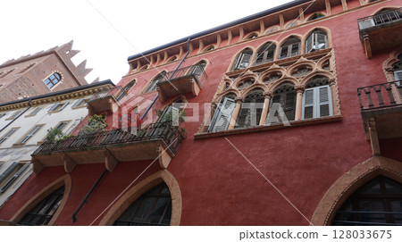 Beautiful traditional Italian building with flowers on balcony of medieval wall, Verona, Italy Beautiful traditional Italian building with flowers on balcony of medieval wall, Verona, Italy 128033675