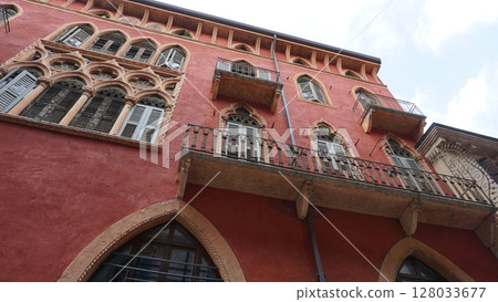 Beautiful traditional Italian building with flowers on balcony of medieval wall, Verona, Italy 128033677
