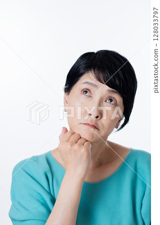 一位身穿淺藍色針織衫的中年婦女正在思考 128033797