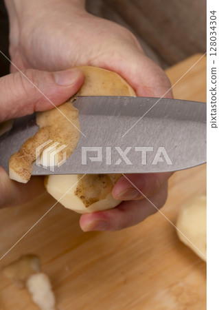 Steps for making vegetable consommé soup: Chop and simmer vegetables; Peel potatoes Steps for making vegetable consommé soup: Chop and simmer vegetables; Peel potatoes 128034304