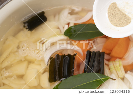 製作蔬菜清湯的步驟：將蔬菜切碎，煮熟，加入胡椒粉 128034316