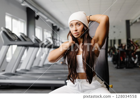Portrait confident beautiful young brunette woman is wearing white beanie Portrait confident beautiful young brunette woman is wearing white beanie 128034558
