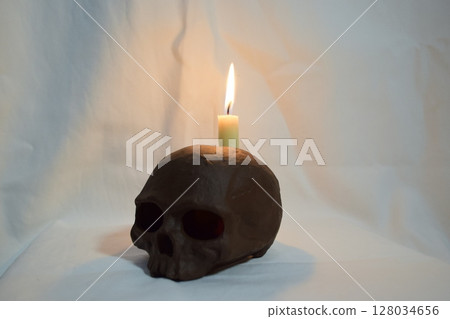 burning candle in the skull 128034656