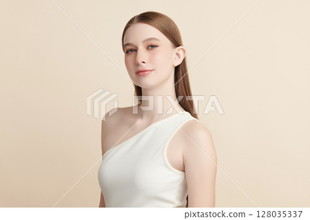 A beautiful young woman with clean, fresh skin against a beige background. Skincare, facial treatment, cosmetology, beauty, and spa. An elegant portrait of an woman. A beautiful young woman with clean, fresh skin against a beige background. Skincare, facial treatment, cosmetology, beauty, and spa. An elegant portrait of an woman. 128035337