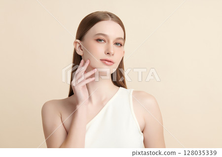 A beautiful young woman with clean, fresh skin against a beige background. Skincare, facial treatment, cosmetology, beauty, and spa. An elegant portrait of an woman. A beautiful young woman with clean, fresh skin against a beige background. Skincare, facial treatment, cosmetology, beauty, and spa. An elegant portrait of an woman. 128035339