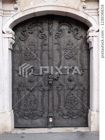 Majestic medieval door with ornate metal pattern and stone columns in Salzburg 128036658