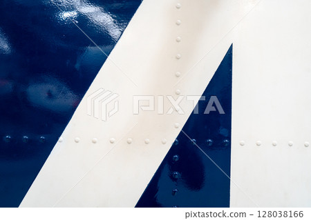 Close-up of riveted blue and white aircraft fuselage with glossy paint Close-up of riveted blue and white aircraft fuselage with glossy paint 128038166