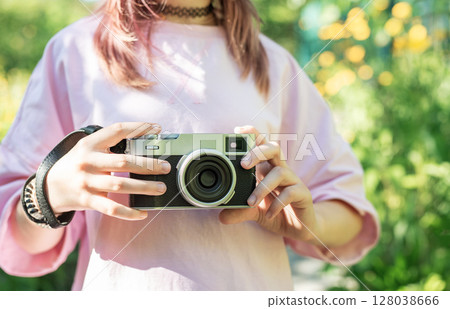 Young photographer capturing nature with vintage camera 128038666