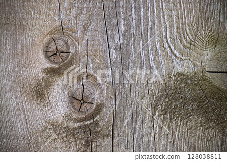 Detailed image of textured weathered wood showing knots and cracks in a close-up view. Detailed image of textured weathered wood showing knots and cracks in a close-up view. 128038811