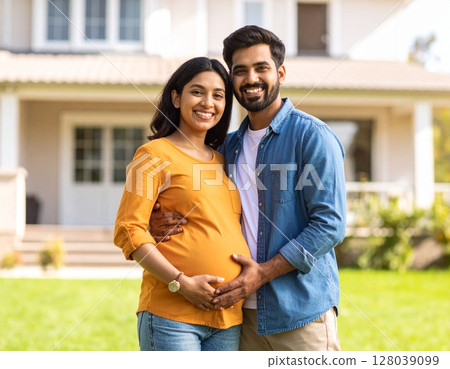 Young Asian pregnant woman and her husband smiling and posing in front of their new house 128039099