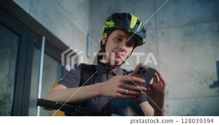 Delivery Woman Notifying Client about Delivery Talking by Phone, Working in Meal Delivery Service Delivery Woman Notifying Client about Delivery Talking by Phone, Working in Meal Delivery Service 128039394
