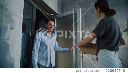 Female Postal Worker Delivering Parcel Box to Addressee, Getting Client's Signature on Digital Tablet Female Postal Worker Delivering Parcel Box to Addressee, Getting Client's Signature on Digital Tablet 128039540