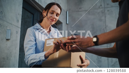 Postal Service Worker Bringing Parcel Box for Client. Businesswoman Signing POD on Smartphone 128039588