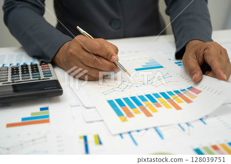 Asian business woman working with financial graph. 128039751