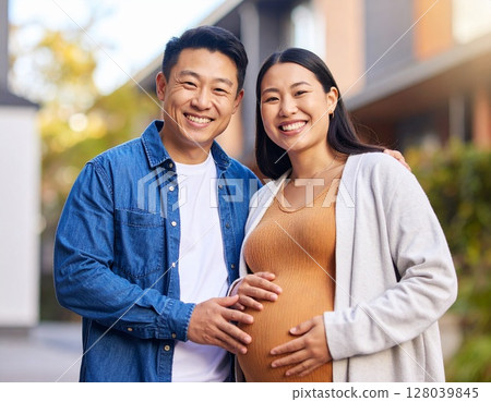 Young Asian pregnant woman and her husband smiling and posing in front of their new apartment 128039845