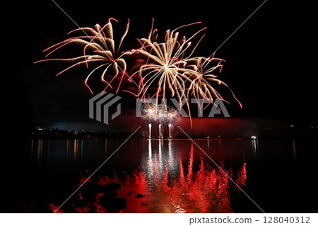 Beautiful colorful fireworks with reflections in water. Brno dam, the city of Brno-Europe. International Fireworks Competition. 128040312