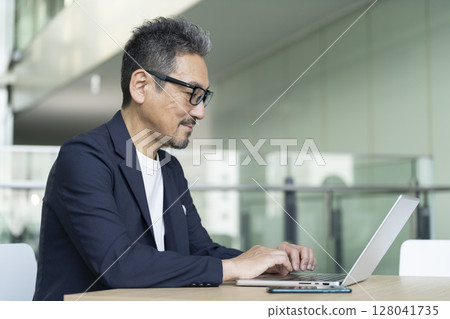 Senior businessman working on a laptop Senior businessman working on a laptop 128041735