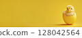 Little chick peering out from cracked egg on yellow backdrop. Easter and new life concept. Long banner 128042564