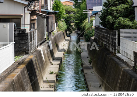 A waterway running through a dense residential area, 128042650