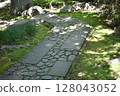A Japanese garden with sunlight filtering through the trees 128043052