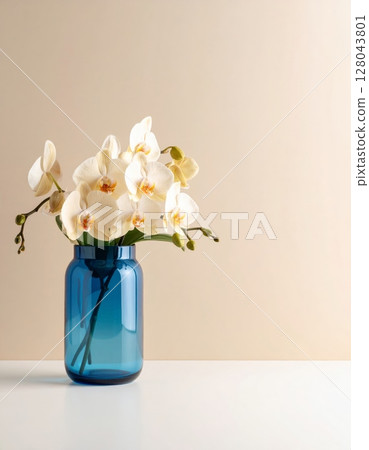 Pink orchid flowers in a glass vase on a table, a beautiful spring nature decoration 128043801