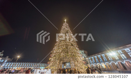 Commerce Square in Lisbon illuminated at Christmas hyperlapse, with a towering tree and crowds celebrating at night. Portugal Commerce Square in Lisbon illuminated at Christmas hyperlapse, with a towering tree and crowds celebrating at night. Portugal 128045107