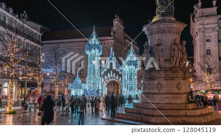 Night timelapse hyperlapse of Christmas decorations with illuminated castle on Luis de Camoes square in Lisbon, Portugal. 128045119