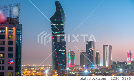 Skyline with Skyscrapers day to night timelapse in Kuwait City downtown illuminated at dusk. Kuwait City, Middle East 128045186