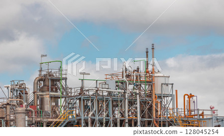 Distillation Columns and their process equipment of hydrogen plant timelapse with clouds on a background. Distillation Columns and their process equipment of hydrogen plant timelapse with clouds on a background. 128045254