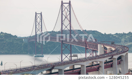 Running Lisbon half marathon crossing the 25 of April bridge over the Tagus river aerial timelapse view from above. 128045255
