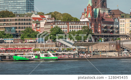 Timelapse of a ferry entering and exiting the Hamburg port terminal, with passengers on the pier and moving on stairs. Timelapse of a ferry entering and exiting the Hamburg port terminal, with passengers on the pier and moving on stairs. 128045435