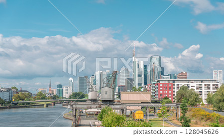 Hyperlapse of Frankfurt's Main Iron Footbridge against the financial district skyscrapers skyline on a sunny day with clouds timelapse. Frankfurt, Germany Hyperlapse of Frankfurt's Main Iron Footbridge against the financial district skyscrapers skyline on a sunny day with clouds timelapse. Frankfurt, Germany 128045626