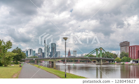 Hyperlapse of Frankfurt's Main Iron Footbridge against the financial district skyscrapers skyline on a sunny day with clouds timelapse. Frankfurt, Germany 128045627