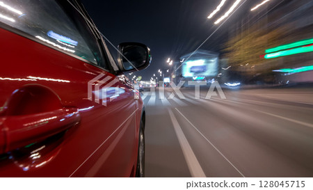 Drivelapse urban look from fast driving car at a night avenue in a city timelapse hyperlapse 128045715