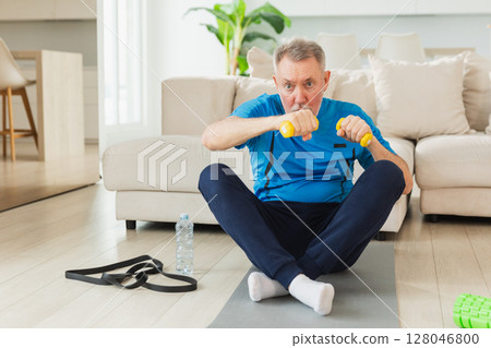 Fitness workout training. Senior man boxing punching picking up dumbbells. Old adult mature healthy man doing sports exercise at home. Grandfather have workout rehabilitation. Health care healthy Fitness workout training. Senior man boxing punching picking up dumbbells. Old adult mature healthy man doing sports exercise at home. Grandfather have workout rehabilitation. Health care healthy 128046800