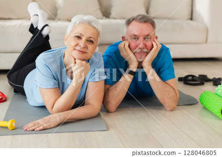 Fitness workout home training. Senior adult mature healthy fit couple resting after sports exercise on yoga mat at home. Mid age old husband wife have training workout. Health care healthy lifestyle 128046805