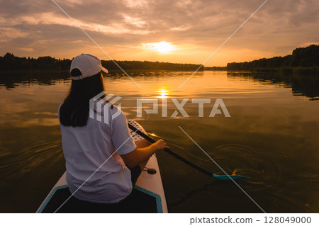 Paddleboarding at Sunset on a Calm Lake Paddleboarding at Sunset on a Calm Lake 128049000