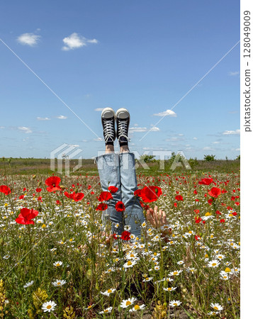 Relaxing in a Field of Poppies and Daisies 128049009