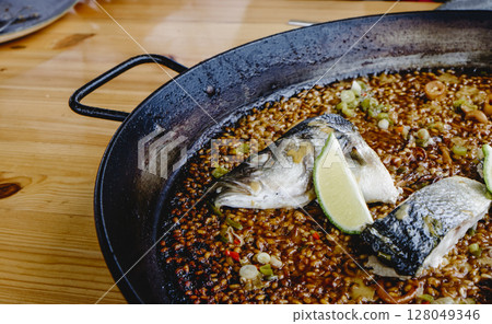 sea bass paella in the cooking pan 128049346
