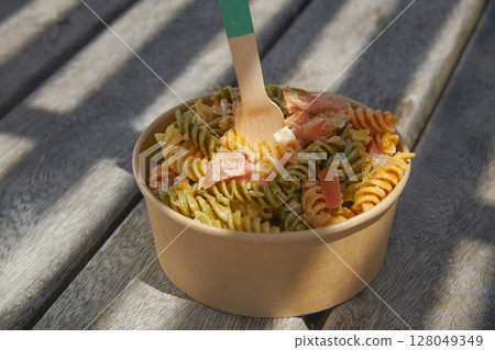 pasta salad on a rustic picnic table 128049349