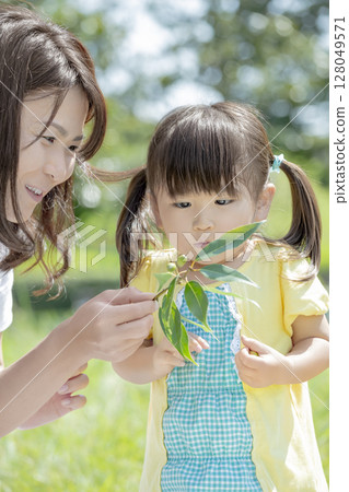 母親和女兒在公園裡看著橡子 128049571