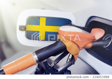 The Sweden flag on the lid of the gas tank of a car at a gas station in close-up. High or low prices for gasoline and diesel fuel at Swedish gas stations. fuel shortage for cars in Sweden. 128051066