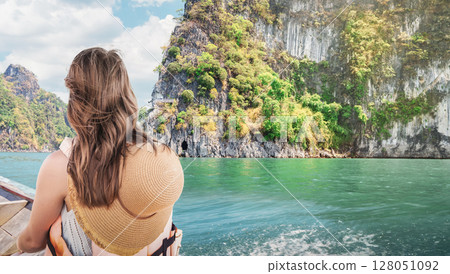 Serene Escape - Female Traveler Admires Emerald Waters of Cheow Lan Lake in Khao Sok National Park, Thailand Close-Up Rear View of Boat Journey 128051092