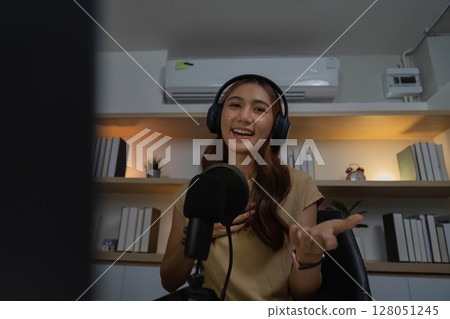 Remote Work and Online Engagement. Smiling woman using headphones in virtual meeting. Remote Work and Online Engagement. Smiling woman using headphones in virtual meeting. 128051245