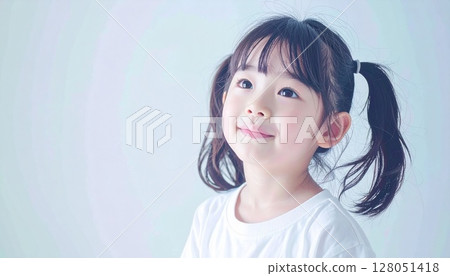 一位雙尾幼兒微笑著斜眼向上看的肖像 128051418