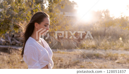 Woman is sitting in the grass Woman is sitting in the grass 128051837
