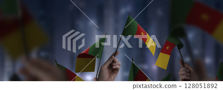 Cameroon flags in their hands on a blurred urban background 128051892