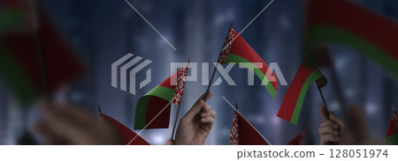 Belarus flags in their hands on a blurred urban background Belarus flags in their hands on a blurred urban background 128051974