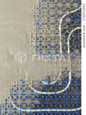 Liquid concrete is poured over floor heating installation in a new building. Modern construction system Liquid concrete is poured over floor heating installation in a new building. Modern construction system 128052093